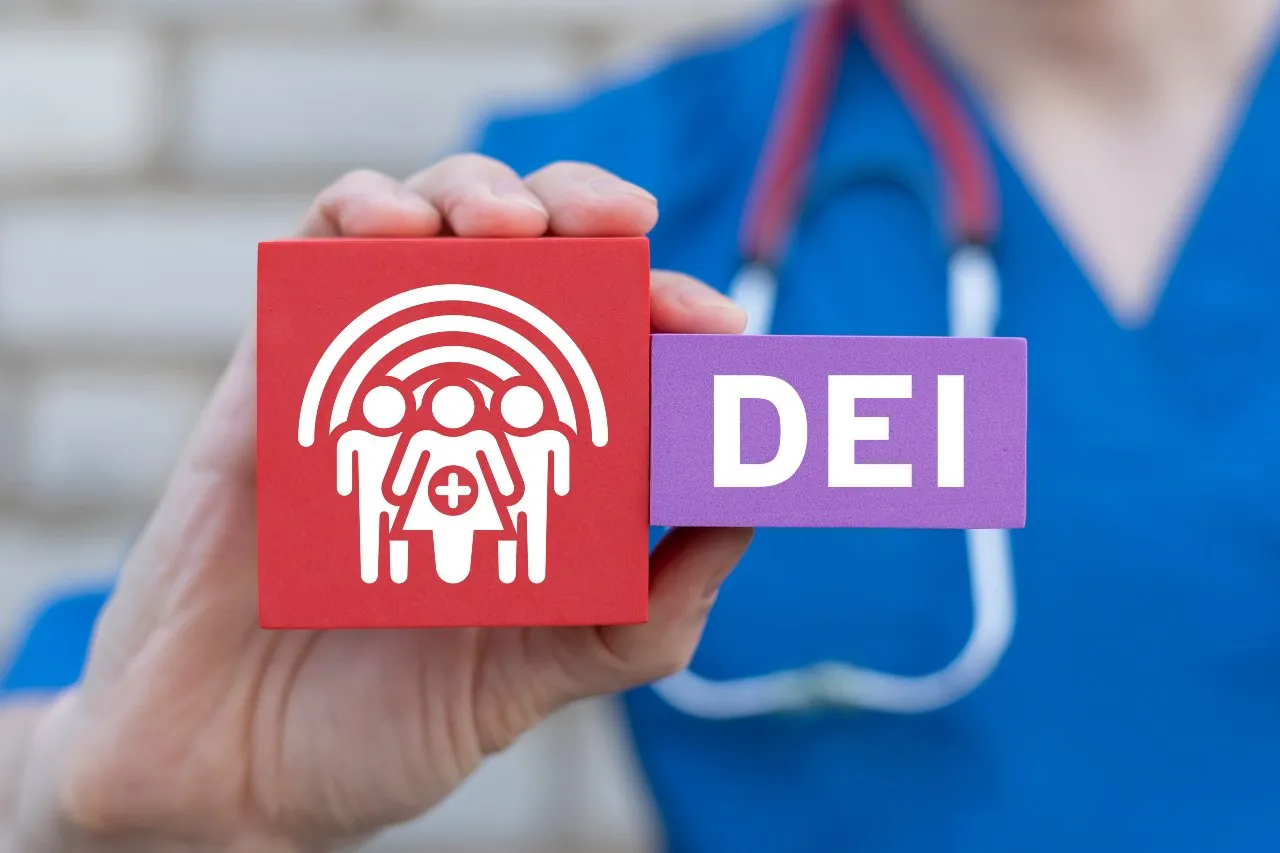 picture of nurse holding heart letters says DEI